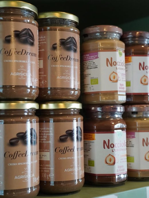 Jars of Sicilian coffee spread stacked two deep on the shelf.