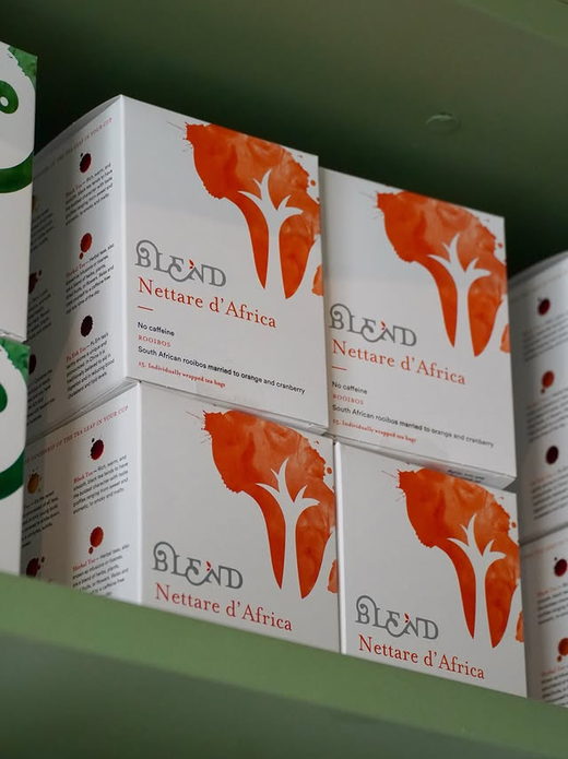 Boxes of Blend Nettare d'Africa rooibos stacked on a sage shelf.